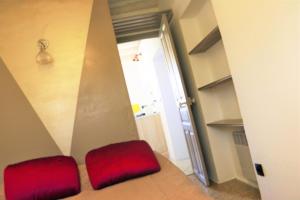 uno sgabello rosso seduto in una stanza con porta di Casa Susini a Pianottoli-Caldarello