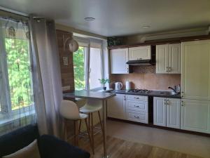 a kitchen with white cabinets and a table and chairs at Amber Stay Birštonas in Birštonas