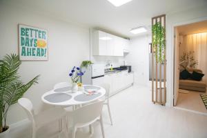 a white kitchen and dining room with a table and chairs at ANNA Stay in Seoul