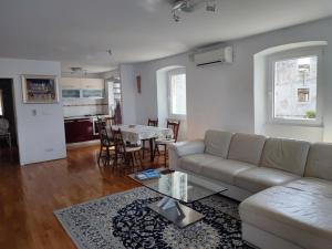 a living room with a couch and a table at Authentic stone house by the sea in Milna