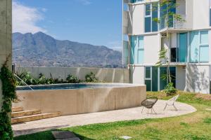 a view of a building with a pool and a chair at Lux at 15, Pool, Gym and Stylish City Stay in Hatillo