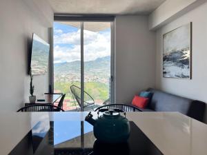 a living room with a glass table and a view at Lux at 15, Pool, Gym and Stylish City Stay in Hatillo