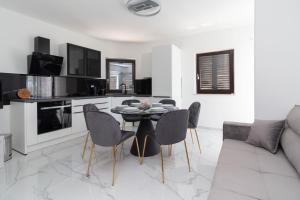a kitchen and living room with a table and chairs at Seaside Apartments Slavica in Petrcane