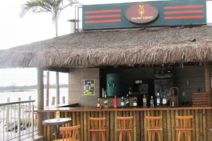 un bar con alcune bottiglie di vino e alcune sedie di Golden Lake - Lazer e Conforto ad Arraial do Cabo