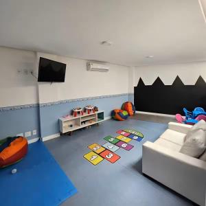 un soggiorno con divano e TV a schermo piatto di Golden Lake - Lazer e Conforto ad Arraial do Cabo