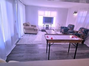 a living room with a table and chairs and a tv at Cozy Ocean Breeze Retreat in Groton