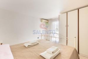 a bedroom with a bed with two towels on it at Salentoandmore-Stella del mare in Torre Pali
