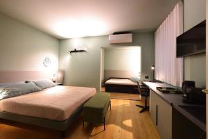 a bedroom with a bed and a desk in it at La Pigna Suites in Verona