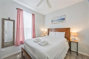 a bedroom with a large bed with two towels on it at Cozy Stylish Townhome in Davenport +24 photos