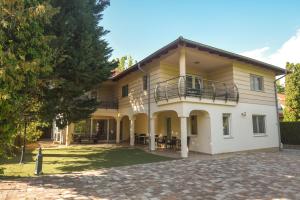 a large house with a balcony on a driveway at Amore Apartmanhaz in Siófok