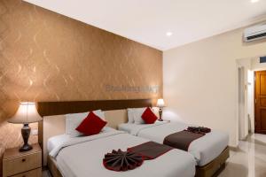 Postel nebo postele na pokoji v ubytování The Kanjeng Hotel Kuta