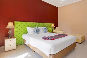 Postel nebo postele na pokoji v ubytování The Kanjeng Hotel Kuta