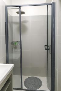 een douche met een glazen deur in een badkamer bij Azania Homes Residence-Opposite Movenpick Hotel in Nairobi