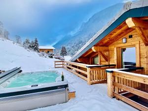 a hot tub in the snow next to a cabin at Chalet Asgard in Morzine