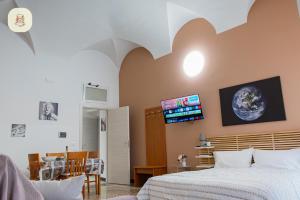 a bedroom with a bed and a tv on the wall at Le Camelie in Genoa