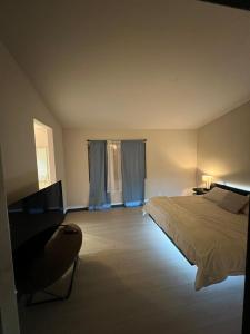 a bedroom with a bed and a chair in a room at Emiliana in Palmdale