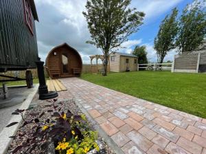 a garden with a small shed in a yard at Heather Cottage and Shepherds Hut in Knock