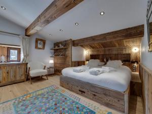 Un dormitorio con una cama grande con una pared de madera. en Chalet skis aux pieds avec piscine et sauna à Val-d'Isère - FR-1-567-126, en Val dʼIsère