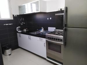 a kitchen with a stove and a refrigerator at נוח ובמרכז העיר in Beer Sheva