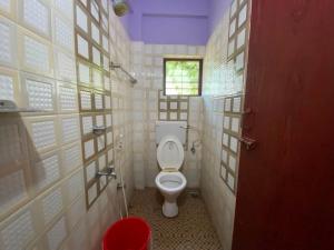 Un pequeño baño con inodoro y ventana. en Hotel O Siva Karthika, en Trivandrum 4 fotos más