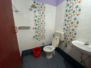 un baño con inodoro y lavabo en Hotel O Siva Karthika, en Trivandrum