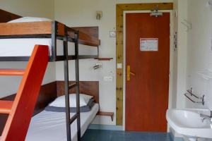 Una habitación con literas con baño y lavabo. en Auberge de Jeunesse HI Belle-Île-en-Mer, en Le Palais