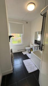 a bathroom with a tub and a toilet and a sink at Spacious room 3 in Bristol