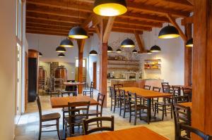 a restaurant with wooden tables and chairs and lights at Pivovar Kulivá Hora in Třebotov
