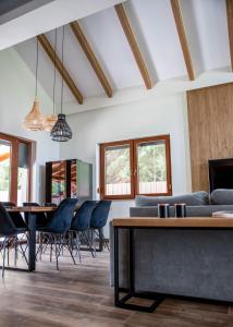 a living room with a couch and tables and chairs at Bonovo Wellness Nyaraló in Gyomaendrőd