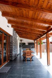 an open patio with a wooden ceiling and a table at Bonovo Wellness Nyaraló in Gyomaendrőd