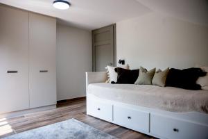 a white bedroom with a large bed with pillows at Bonovo Wellness Nyaraló in Gyomaendrőd +49 photos