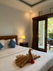 a bedroom with a bed with a stuffed bird on it at Sabar House Ubud View by EPS in Ubud