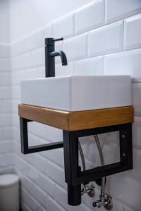a bathroom sink with a black and wooden stand at Bonovo Wellness Nyaraló in Gyomaendrőd