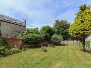 a garden with a bench and a tree at Sea Holly in Lyme Regis