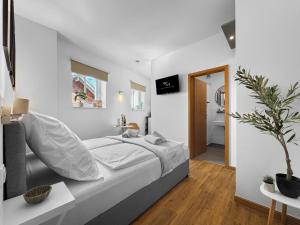 a white bedroom with a bed and a bathroom at Exklusives Studio 4 in Steinfeld in Steinfeld +6 photos
