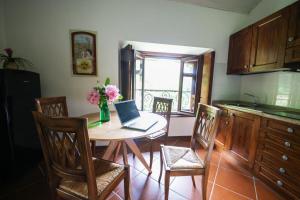 a kitchen with a table with a laptop on it at Rosa del Sasso in Lanzo dʼIntelvi