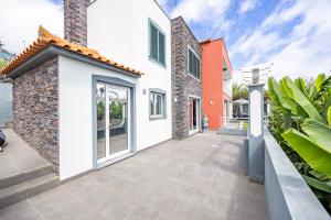 a house with white walls and a courtyard at Casa da Fonte by YOUR KEY - 1st floor house in Ribeira Brava