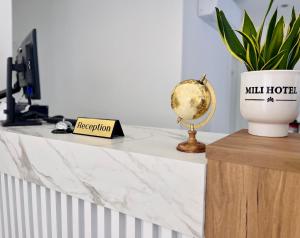a white marble counter with a potted plant on it at Mili Hotel in Berat