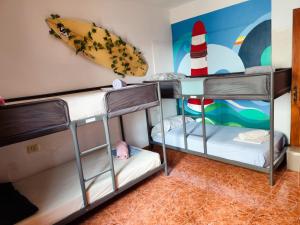2 łóżka piętrowe w pokoju z deską surfingową na ścianie w obiekcie Banana Surf House w mieście Los Cristianos +37 zdjęć