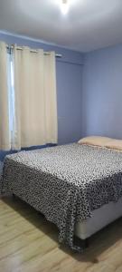 a bedroom with a bed with a black and white comforter at Apartamento confortavel a cinco minutos da praia de icarai in Niterói +36 photos