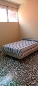 Un dormitorio con una cama en una habitación con ventana. en Casa San Fernando, Ahuachapan, en Ahuachapán