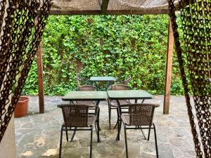 a patio with tables and chairs and a hedge at Casa Parranxo in Senterada