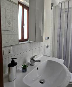 a white sink in a bathroom with a mirror at La casa di Serafina in Santo Stefano di Camastra