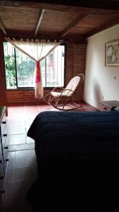 una camera da letto con due sedie e un letto e una finestra di Villa Paz a Villa Allende