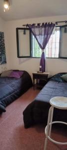 una camera da letto con due letti, un tavolo e una finestra di Villa Paz a Villa Allende