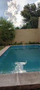 una piscina con acqua blu in un cortile di Villa Paz a Villa Allende