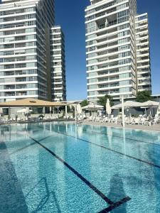 a large swimming pool with some chairs and buildings at Sea pearl tower in Netanya