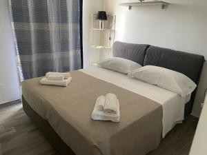 a bed with two pairs of slippers on top of it at Lady Marzamemi in Marzamemi