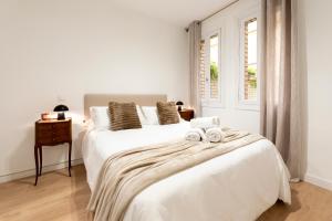 ein weißes Schlafzimmer mit einem großen Bett mit Handtüchern darauf in der Unterkunft Apartamento de 1 dormitorio cerca de Plaza España-Madrid Temporal PEZ14 in Madrid