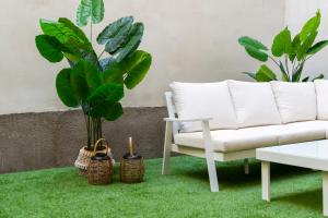 ein Wohnzimmer mit einem weißen Sofa und zwei Pflanzen in der Unterkunft Apartamento de 1 dormitorio cerca de Plaza España-Madrid Temporal PEZ14 in Madrid